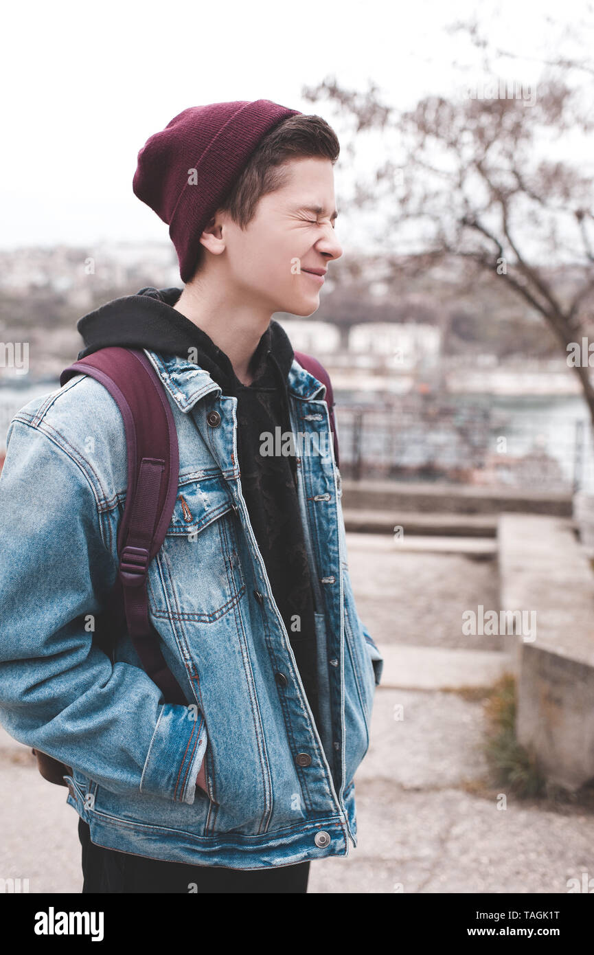 Funny teen garçon 14-16 ans rire à l'extérieur. Veste en jean, en portant  un chapeau et sac à dos. Des émotions positives Photo Stock - Alamy