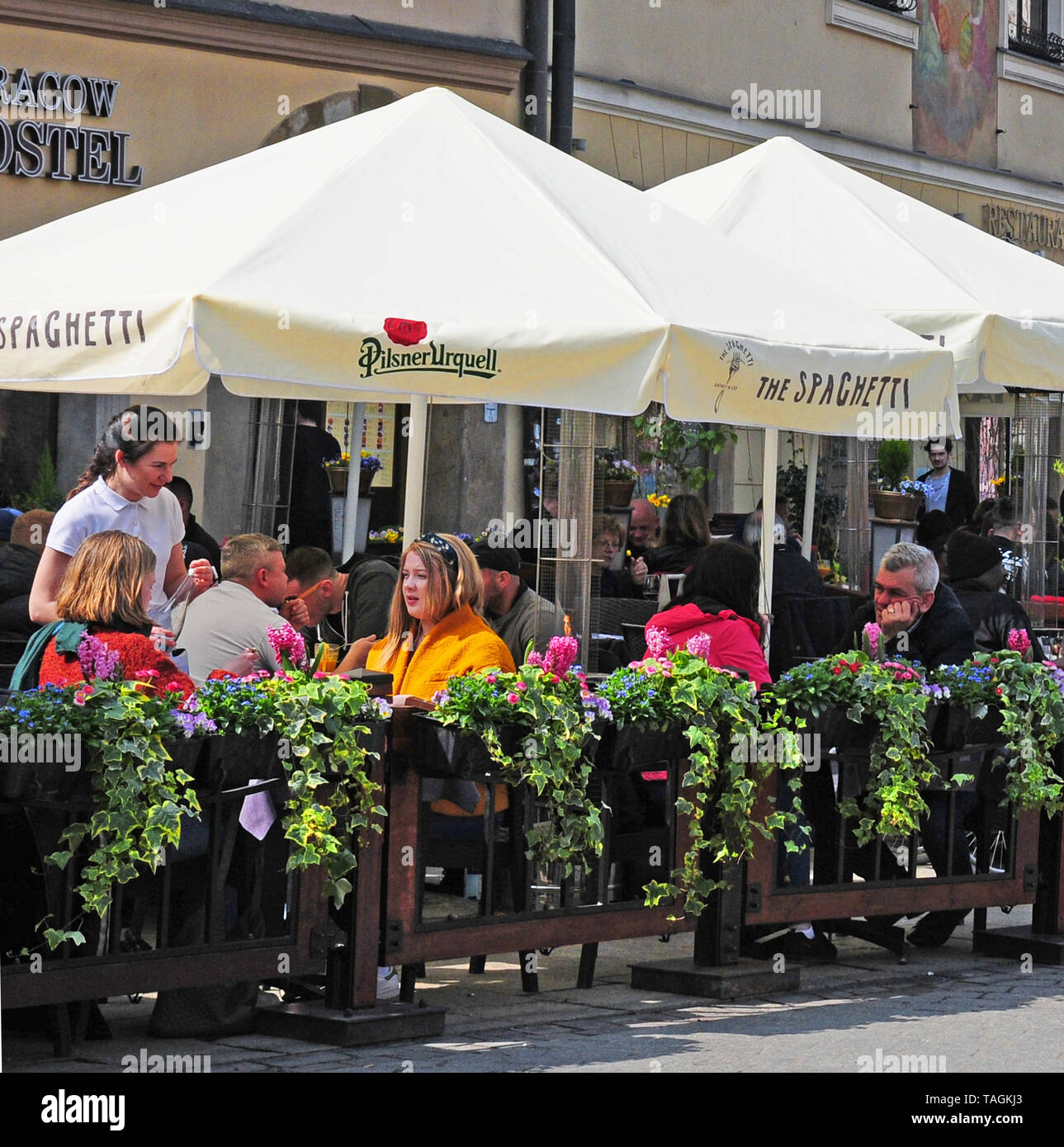 Les gens manger dehors dans la vieille place de la ville, Cracovie, Pologne. Banque D'Images