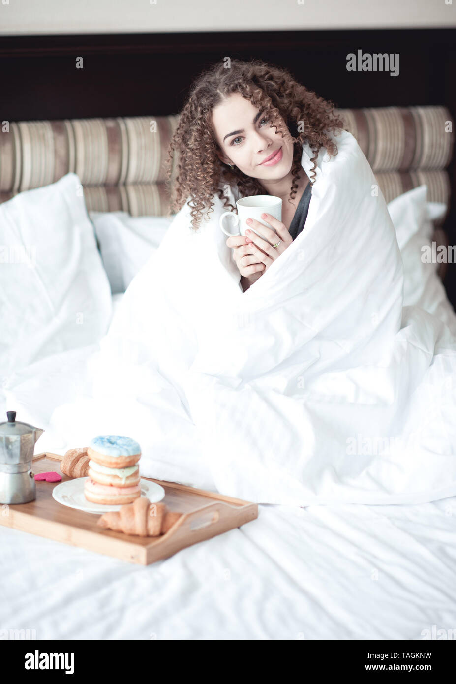 Woman 24 à 29 ans, la consommation de thé au lit. Bonjour. 20s. Banque D'Images