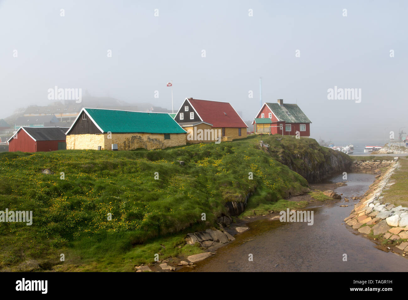 Vue générale des bâtiments et du ruisseau menant à la marina dans le village de Paamiut sur la côte ouest du Groenland. Banque D'Images