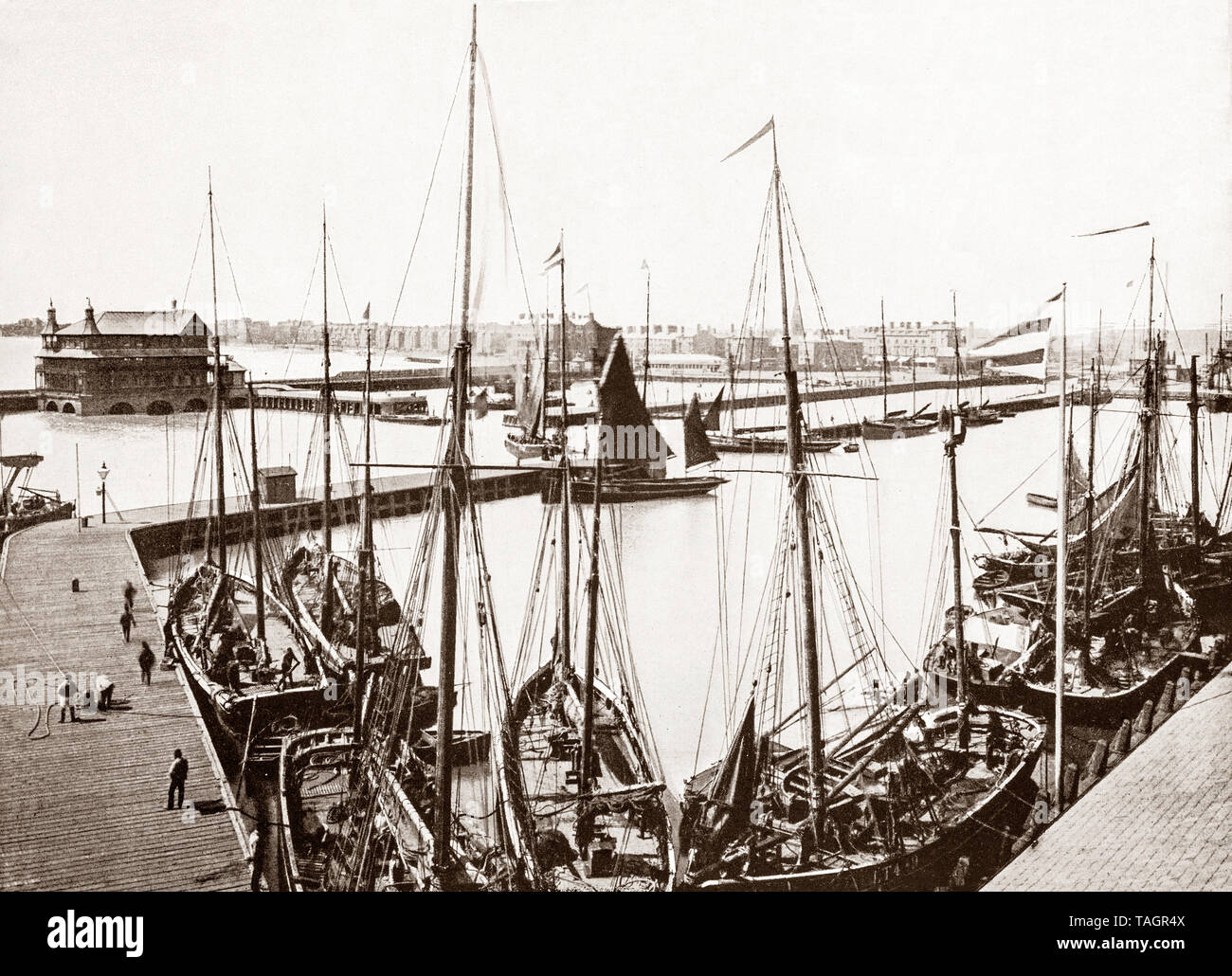 Une fin du 19e siècle voir des bateaux de pêche dans le port de Lowestoft, une ville sur la côte de la mer du Nord dans le comté de Suffolk. En tant que ville portuaire, elle est élaborée à partir de l'industrie de la pêche et avec grandes plages de sable fin, deux jetées et d'autres attractions il est devenu une station balnéaire traditionnelle. Au xixe siècle, le chemin de fer de Lowestoft & Harbour Company, reliant la ville avec Reedham et la ville de Norwich, pour aider à stimuler le développement de l'industrie de la pêche. Banque D'Images