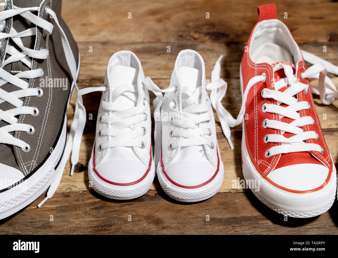 Image conceptuelle de gumshoes sneakers chaussures de père et mère fils  fille famille sur plancher de bois vintage dans différentes tailles en  douce à la maison togetherne Photo Stock - Alamy