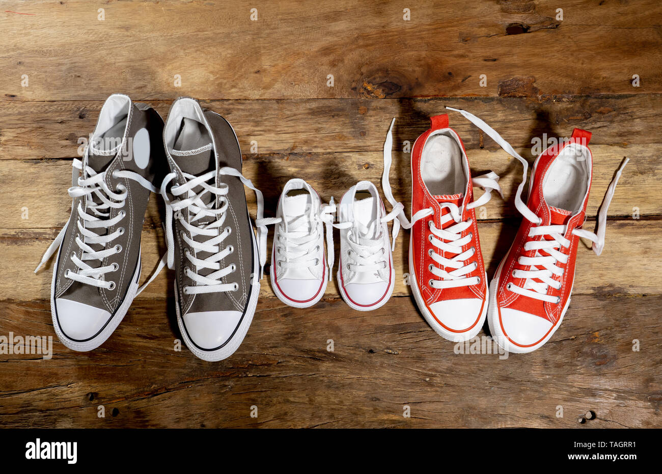 Image conceptuelle de gumshoes sneakers chaussures de père et mère fils  fille famille sur plancher de bois vintage dans différentes tailles en  douce à la maison togetherne Photo Stock - Alamy