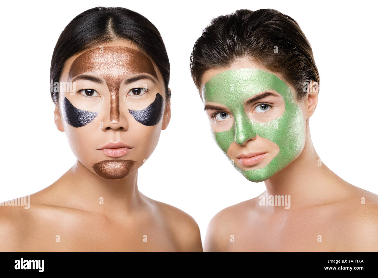 Deux belles filles avec des masques peel-off sur leurs visages. Isolé sur fond blanc Banque D'Images