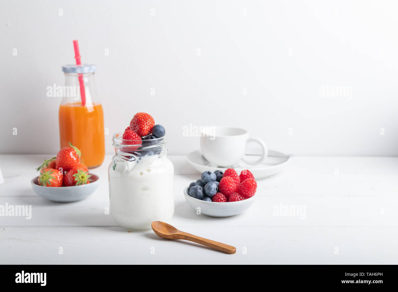 Le yogourt aux fraises, framboises et bleuets sur une table de petit déjeuner. Isolé sur fond blanc Banque D'Images