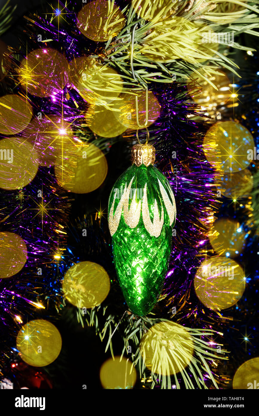 Babiole décorative de Noël vert est sur un arbre de Noël entouré de guirlandes et de lumières de fête Banque D'Images