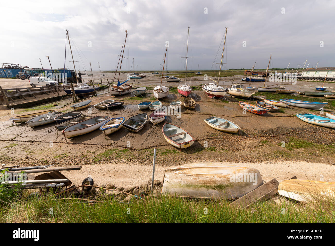Un grand nombre de barques et bateaux disponibles assis sur la boue à Leigh on Sea, Essex, UK à marée basse. Météo variable avec des nuages menaçants Banque D'Images