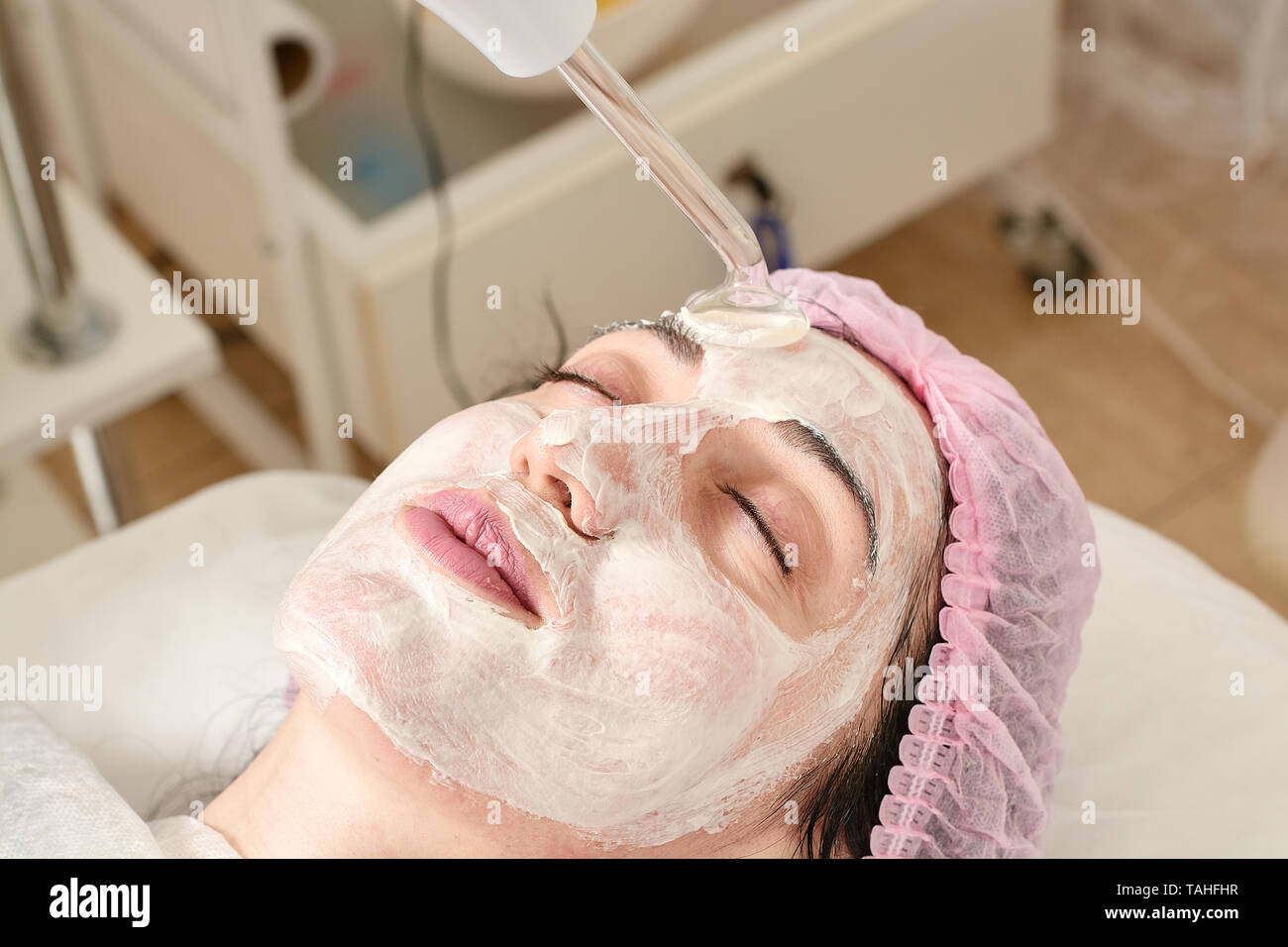 Jeune femme en instituts de beauté, de rajeunissement n'procédure darsonval tonique sur le visage. L'équipement médical de soins de beauté. Close-up beauté intérieur. Banque D'Images