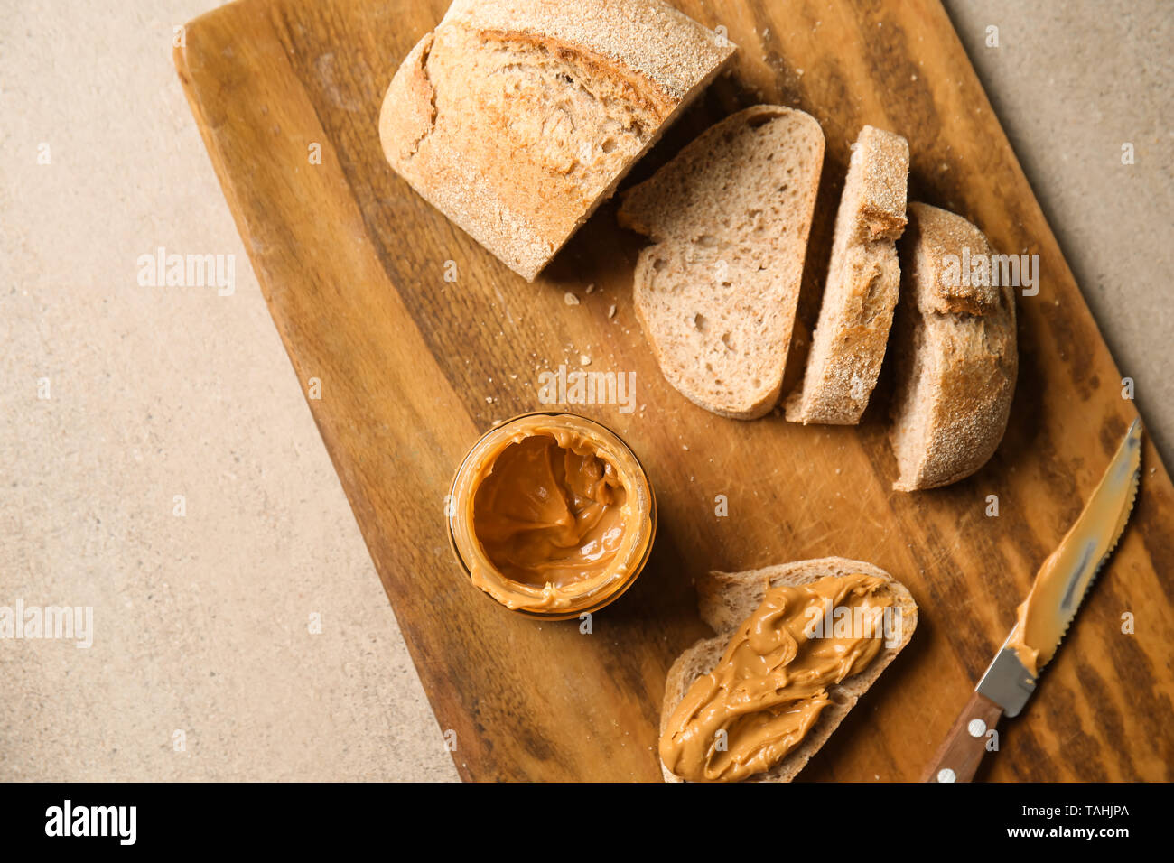 Du pain frais avec du beurre d'arachide sur planche de bois Banque D'Images