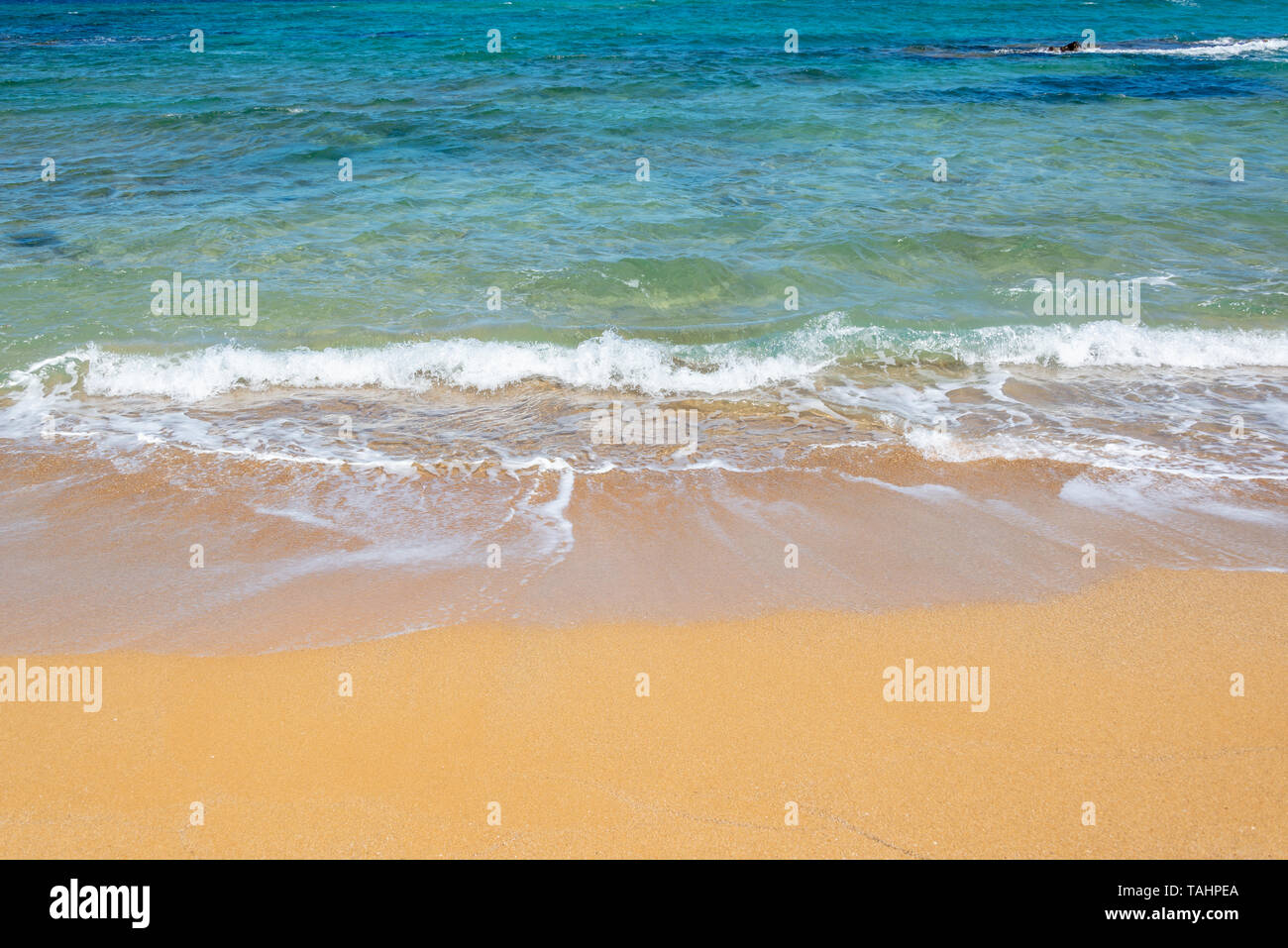 Les vagues sur une plage de sable et d'eau bleu orange Banque D'Images