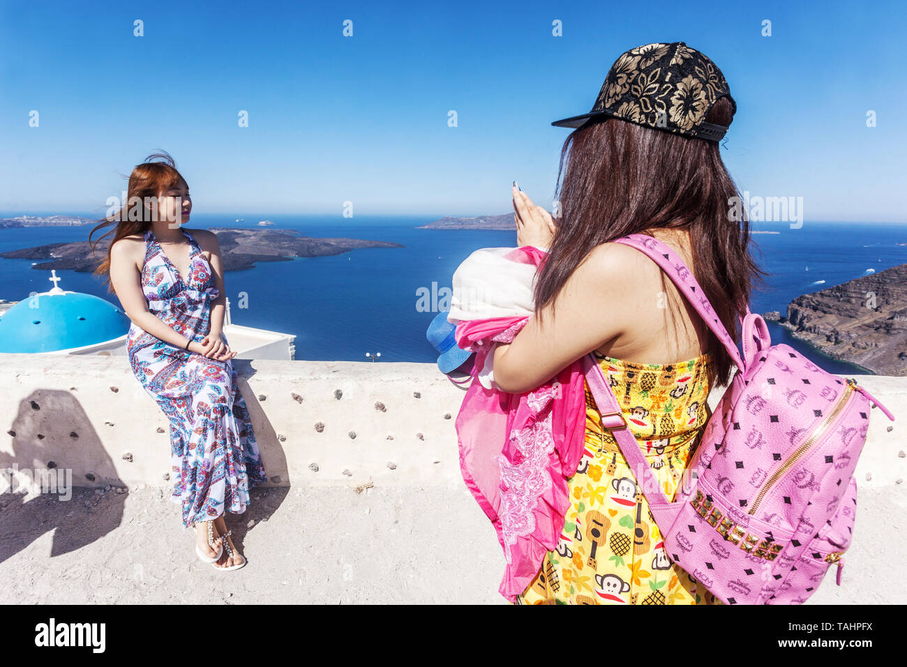 Deux jeunes femmes asiatiques touristes prenant la photo avec le téléphone, la marque de sac à dos de mode MCM, Santorin Îles grecques Grèce, Europe voyageurs Banque D'Images
