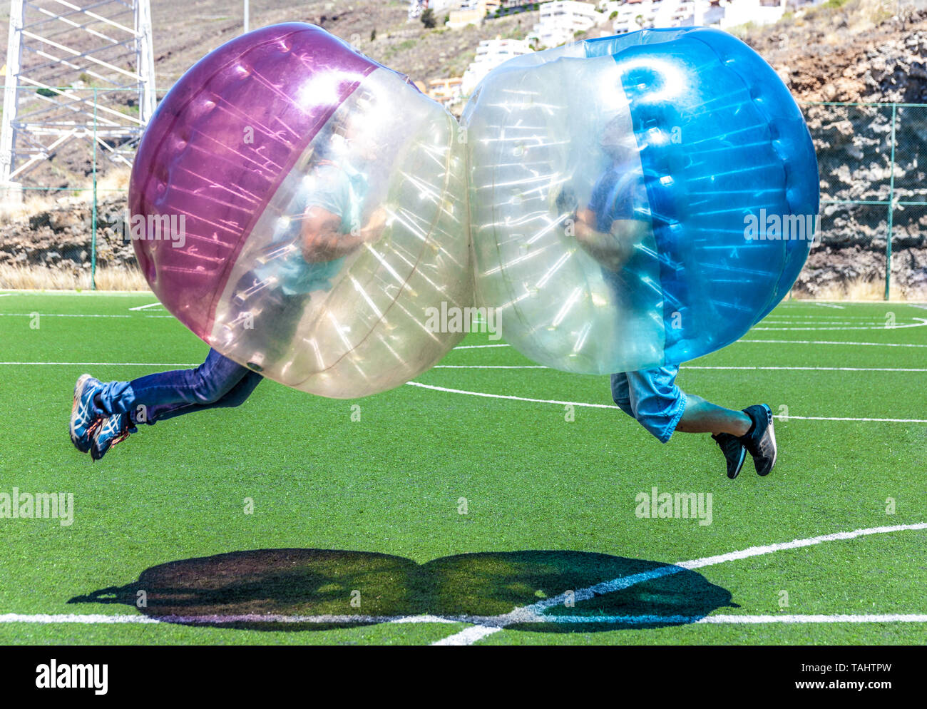 Les jeunes mâles adultes jouant avec des bulles de soccer Banque D'Images