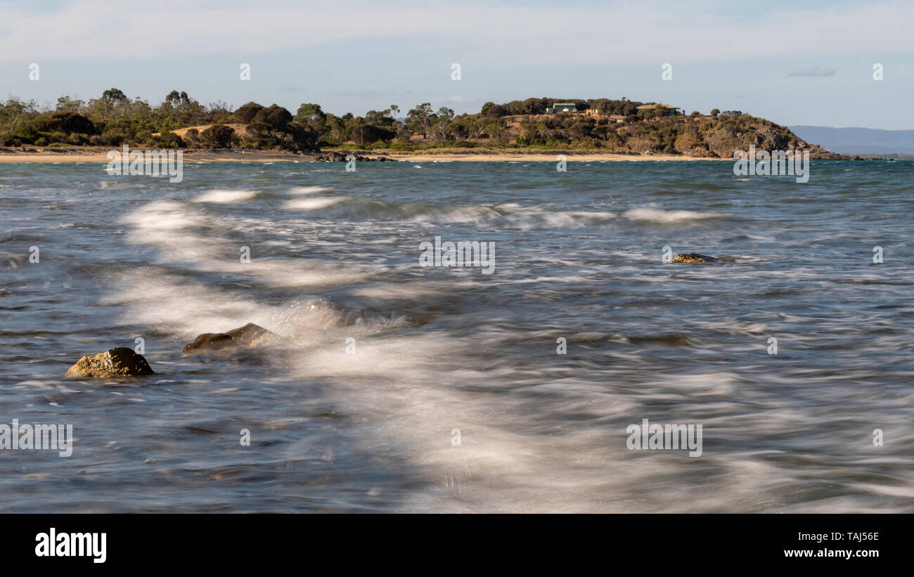 Déferlement des vagues sur les rochers, de flou, de la plage en arrière-plan Banque D'Images