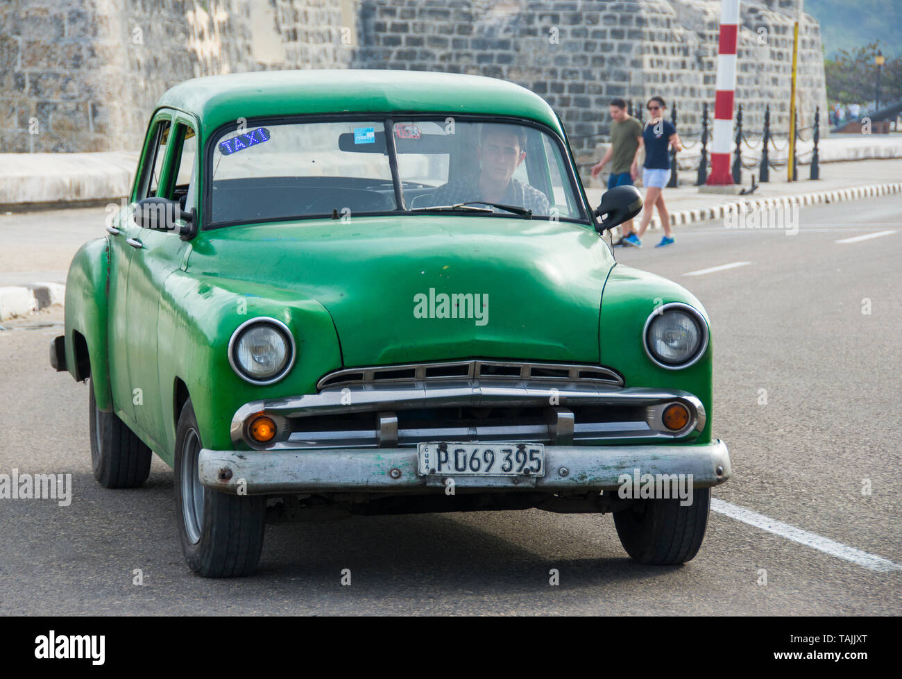 La Havane, Cuba - Un taxi passe devant Castillo de San Salvador de la Punta Sur le Malecón road face à la baie de La Havane. Voitures américaines classiques du 19 Banque D'Images