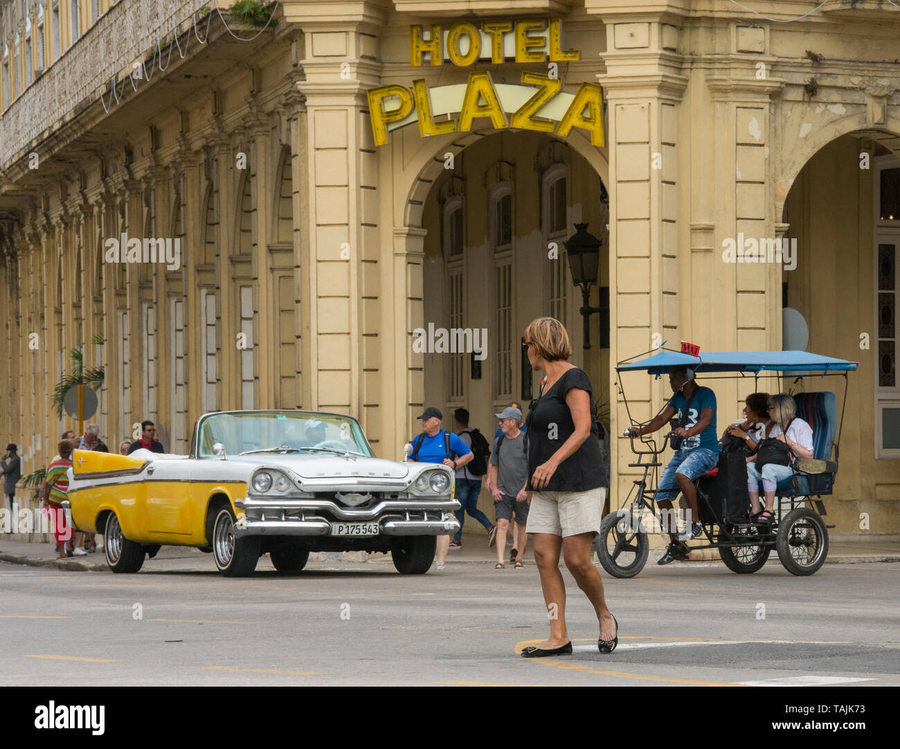 La Havane, Cuba - un taxi et un vélo taxi passent devant l'hôtel Plaza près de Parque Central. Classic voitures américaines des années 50, importées avant l'U Banque D'Images