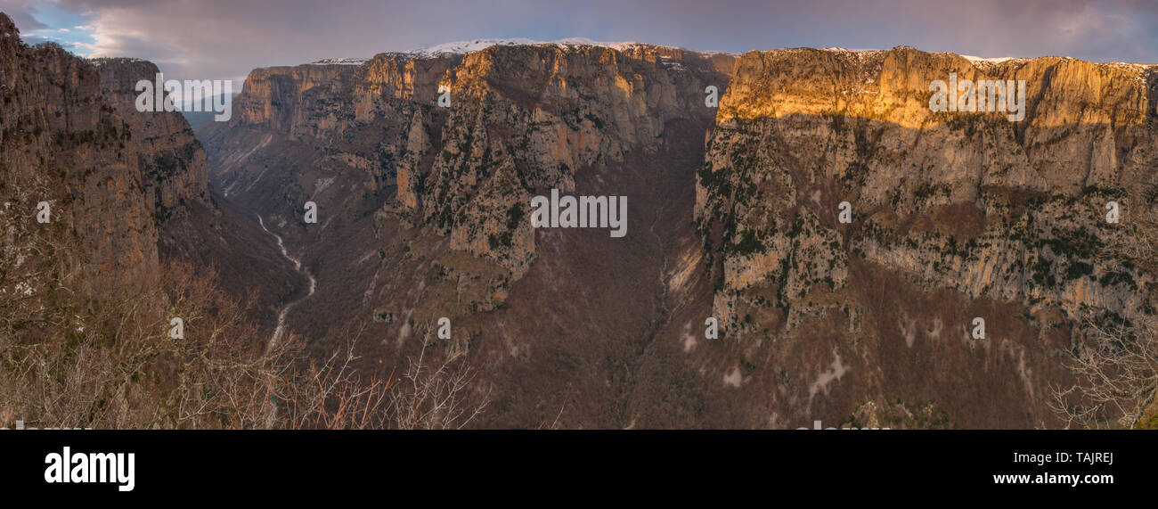 Vue panoramique sur le canyon de Vikos de Oxia point de vue. Vue sur le coucher du soleil de Vikos avec un ciel coloré, profond canyon au crépuscule. Coucher du soleil vif en Grèce. Banque D'Images