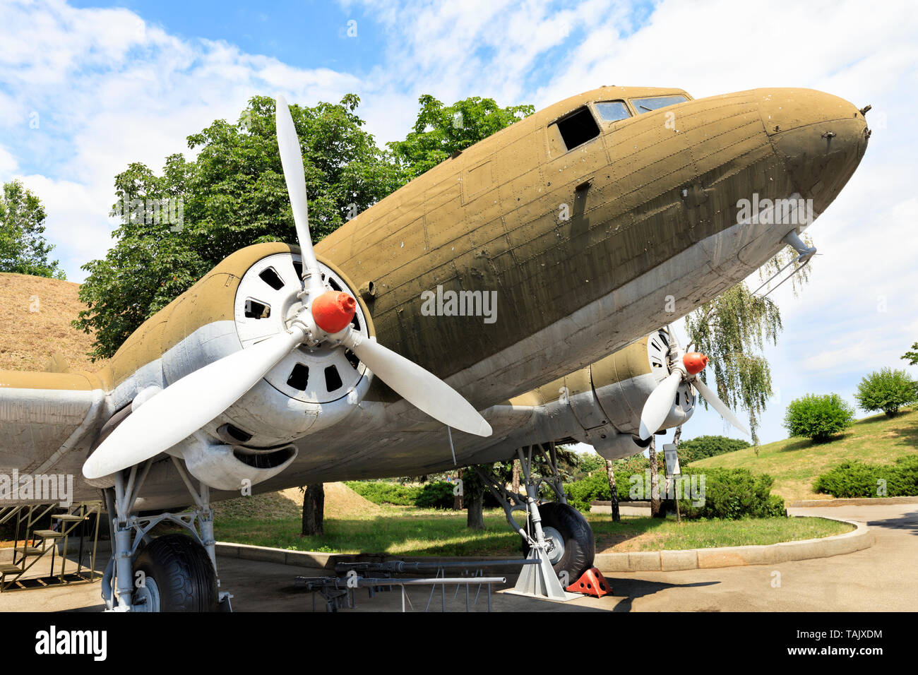 Un vieux avions militaires de transport Lisunov Li-2 de la Deuxième Guerre mondiale, se dresse dans un parc contre un ciel bleu nuageux. Banque D'Images