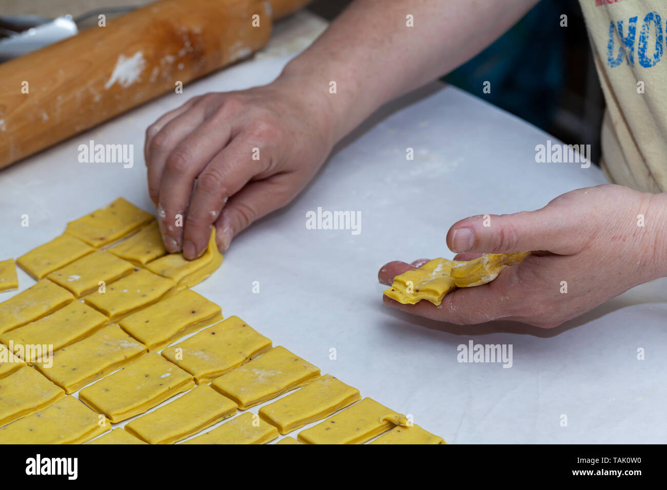 Placer une femme pour couper la pâte des boulettes de poulet et du Sud dans sa main avant de le placer dans la marmite. Banque D'Images