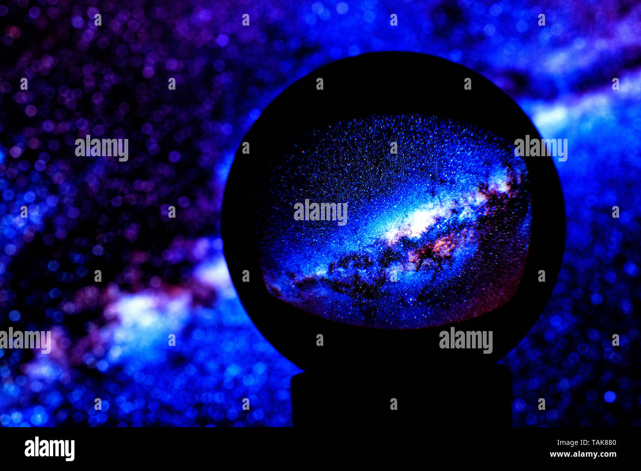 Étoile de la Voie lactée se reflètent dans une boule de cristal bleu sur un arrière-plan flou, sur le côté gauche de la copie de l'espace. Banque D'Images