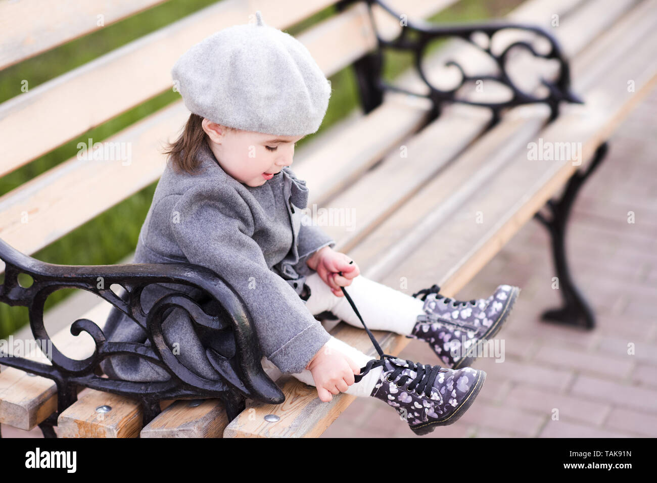 Chaussures bébé fille dentelle assis sur un banc de parc. Portant béret à  la française et du pelage. L'enfance Photo Stock - Alamy
