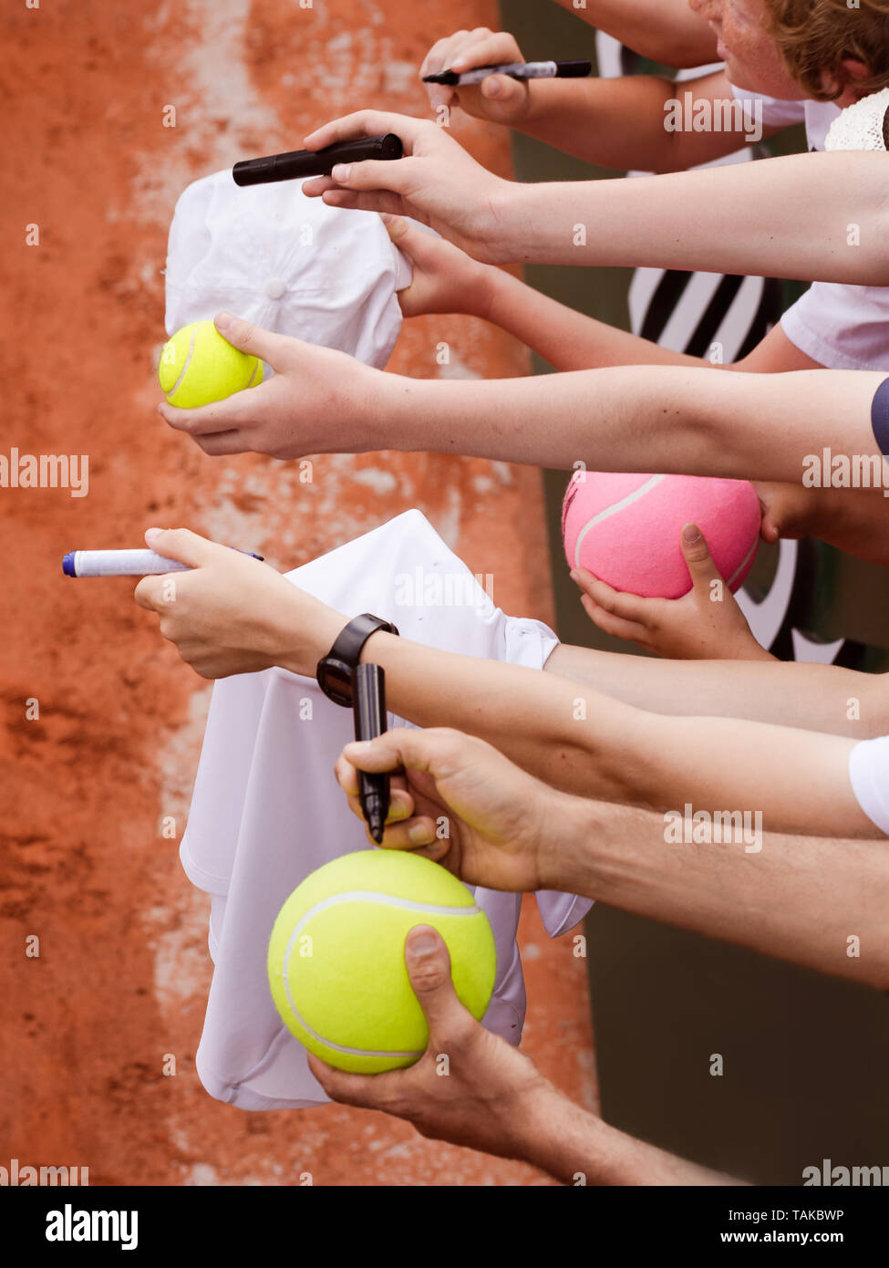 Tennis fans d'étendre les mains pour offrir des ballons et des chapeaux pour obtenir un autographe de joueur de tennis après win, photo gros plan montrant les mains en attente de joueur Banque D'Images
