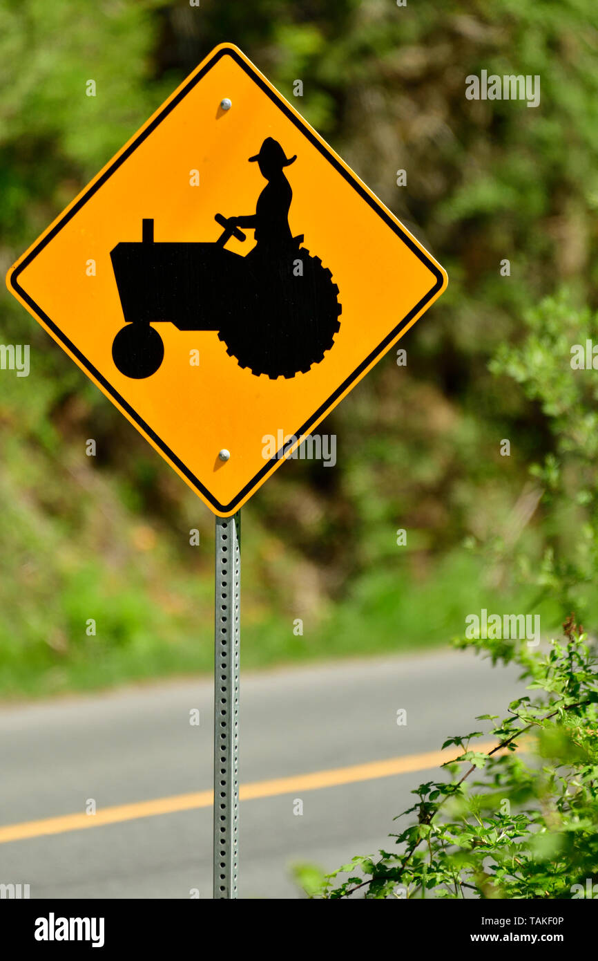 Une image verticale d'une signalisation routière les automobilistes d'avertissement qu'il y a peut-être des machines agricoles lent sur la route Banque D'Images
