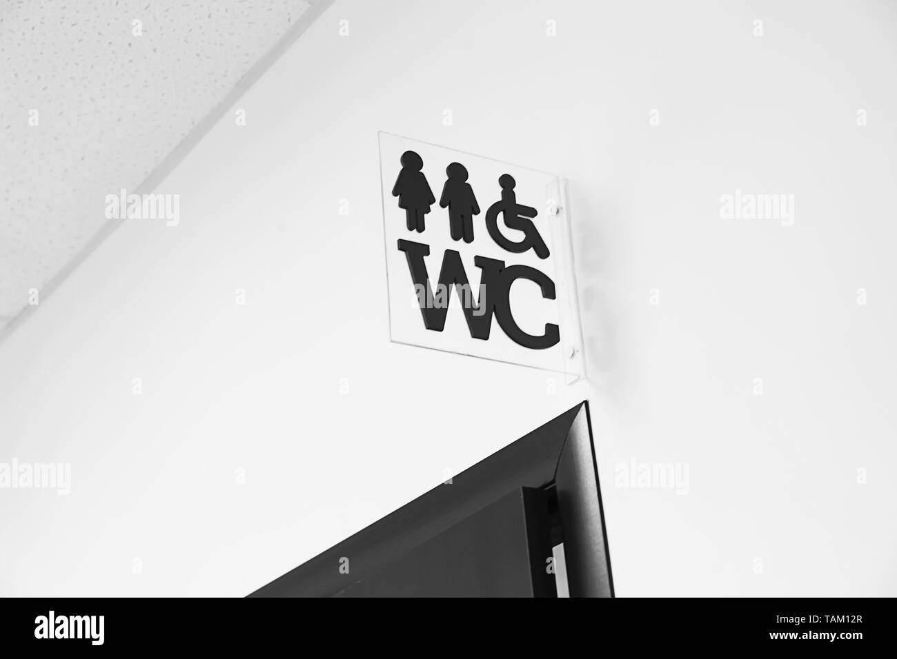 WC signe sur mur près de la porte des toilettes Banque D'Images