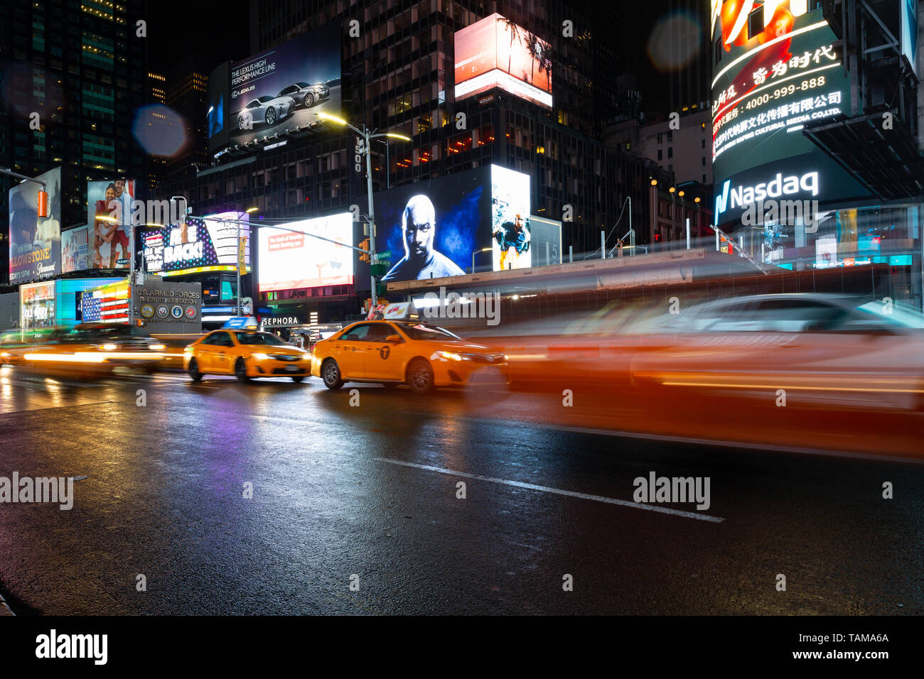 Une longue exposition de taxi à Times Square dans la nuit - New York, NY Banque D'Images