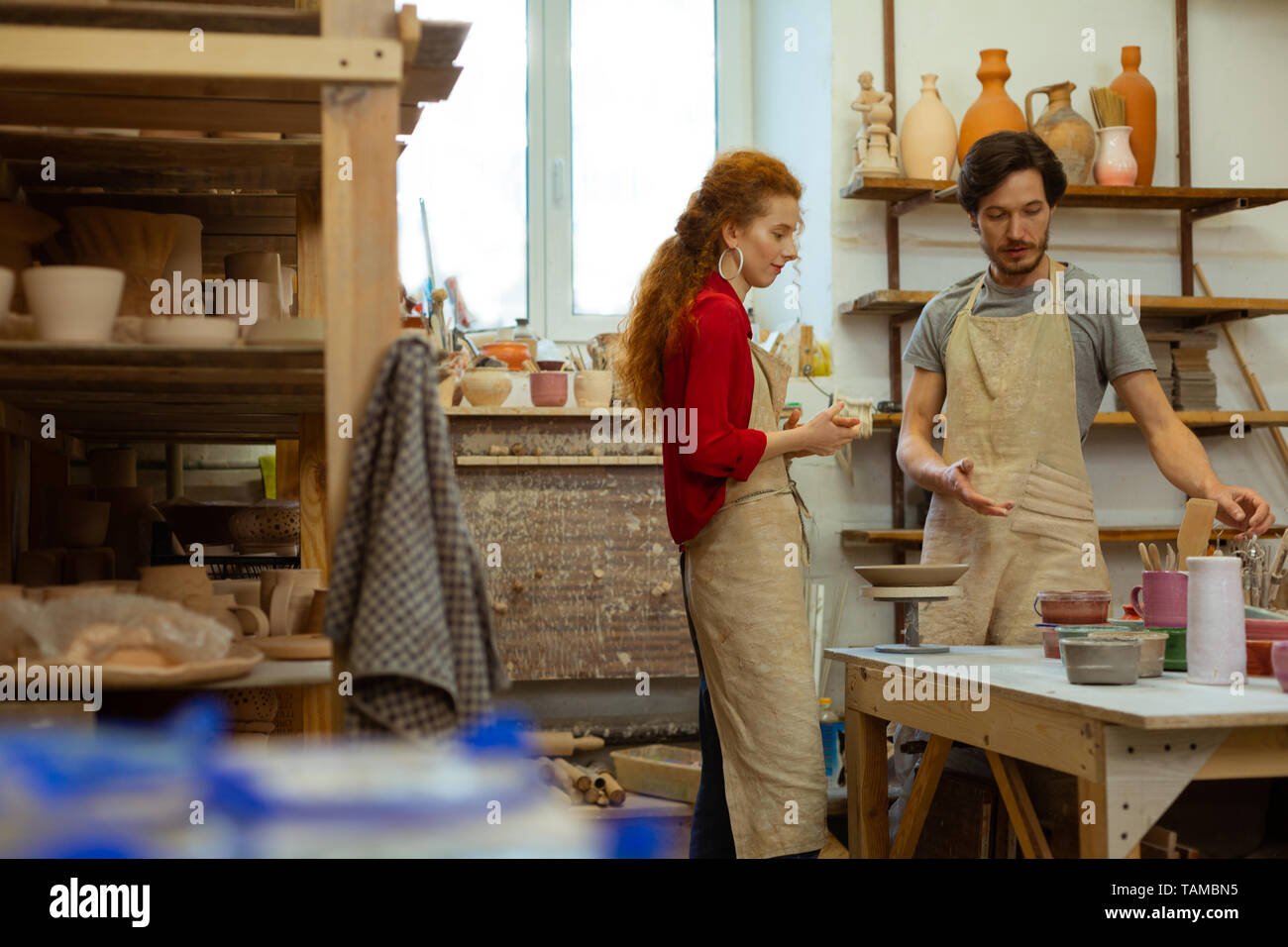 Morceaux de l'argile. Agréable bonne-couple à la recherche d'un séjour en studio équipé et discuter de procédure dans l'art de la poterie Banque D'Images