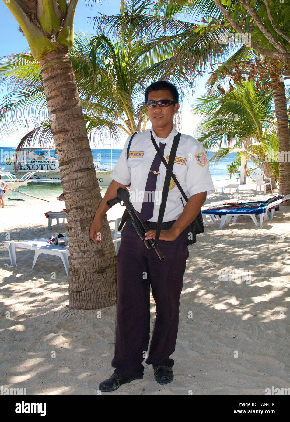 Homme de sécurité armés à la plage d'un recours, Bounty beach, Malapascua Island, Cebu, Philippines Banque D'Images