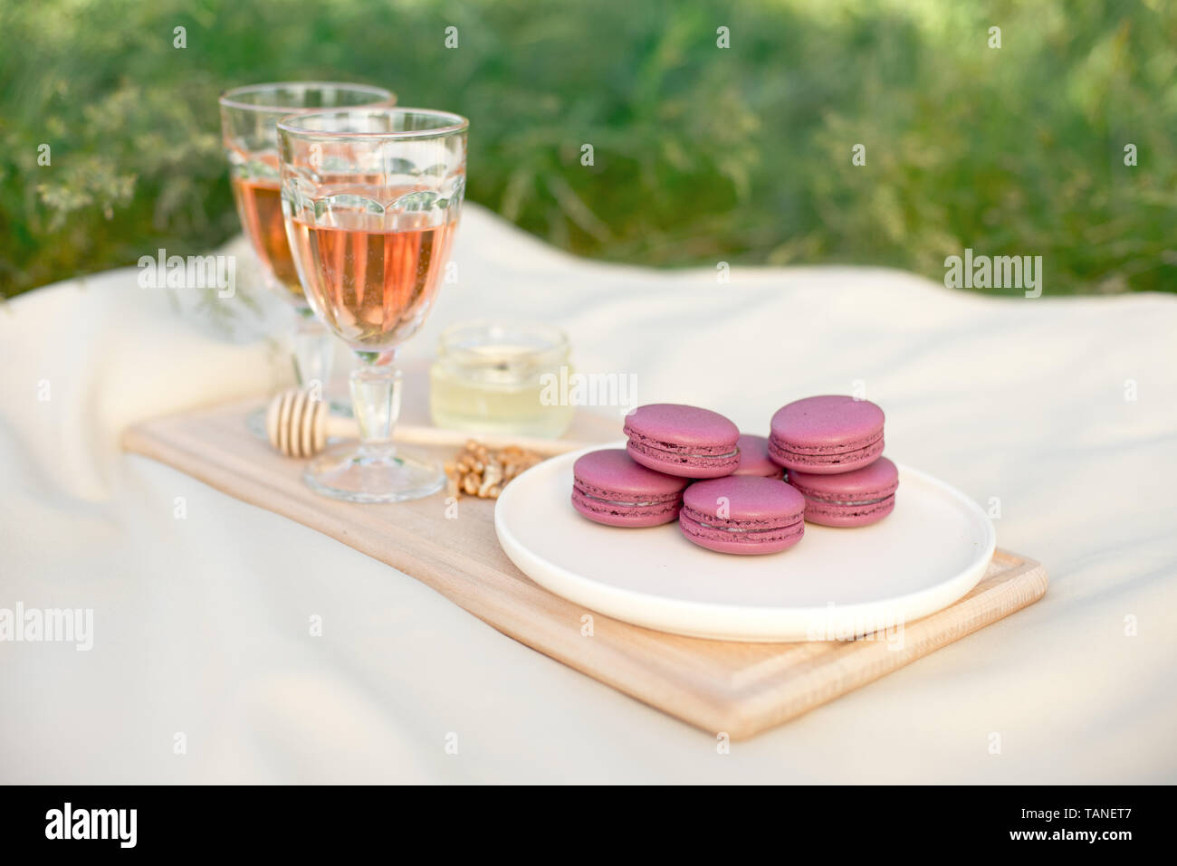 Rose clair et rose fushia macarons macarons français ou en verre avec des  gobelets de vin rose à une plaque blanche sur une nappe beige background  Photo Stock - Alamy
