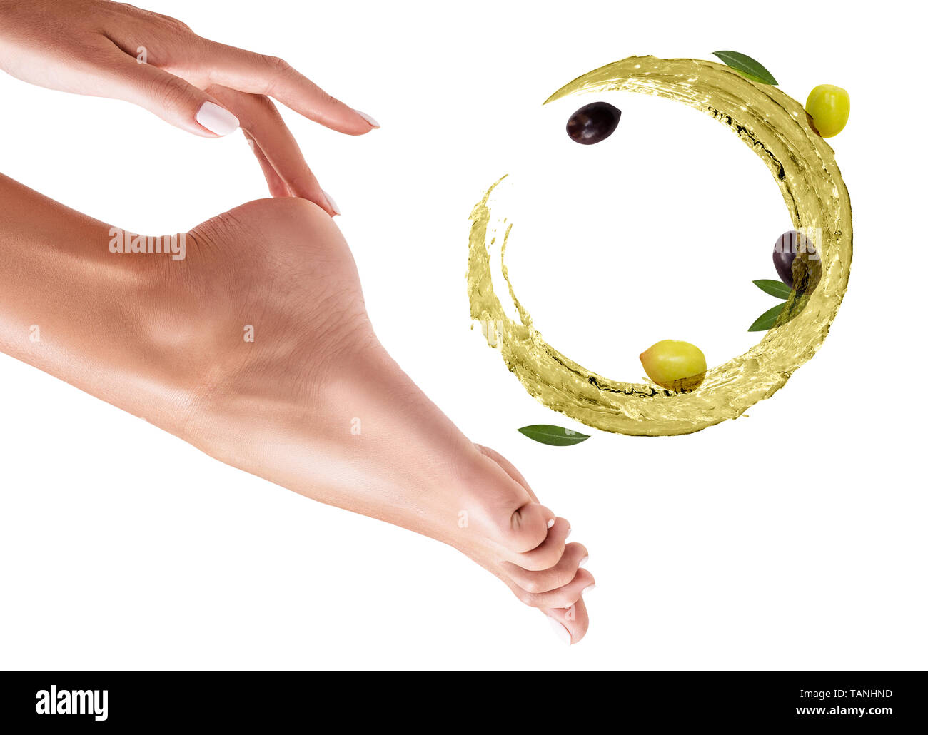 Faire circuler l'éclaboussure d'huile d'olive près de pieds femelles. Concept de Soin. Banque D'Images