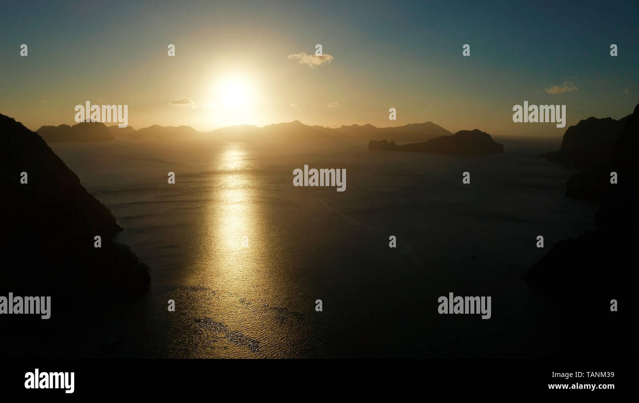 Drone aérien seascape avec montagnes et îles rocheuses dans le temps du matin. d'El Nido, coucher de soleil sur la mer. tropical bay dans au coucher du soleil. Ciel de coucher du soleil et les montagnes des roches de la baie. Coucher de soleil de rêve au milieu des rochers. Banque D'Images