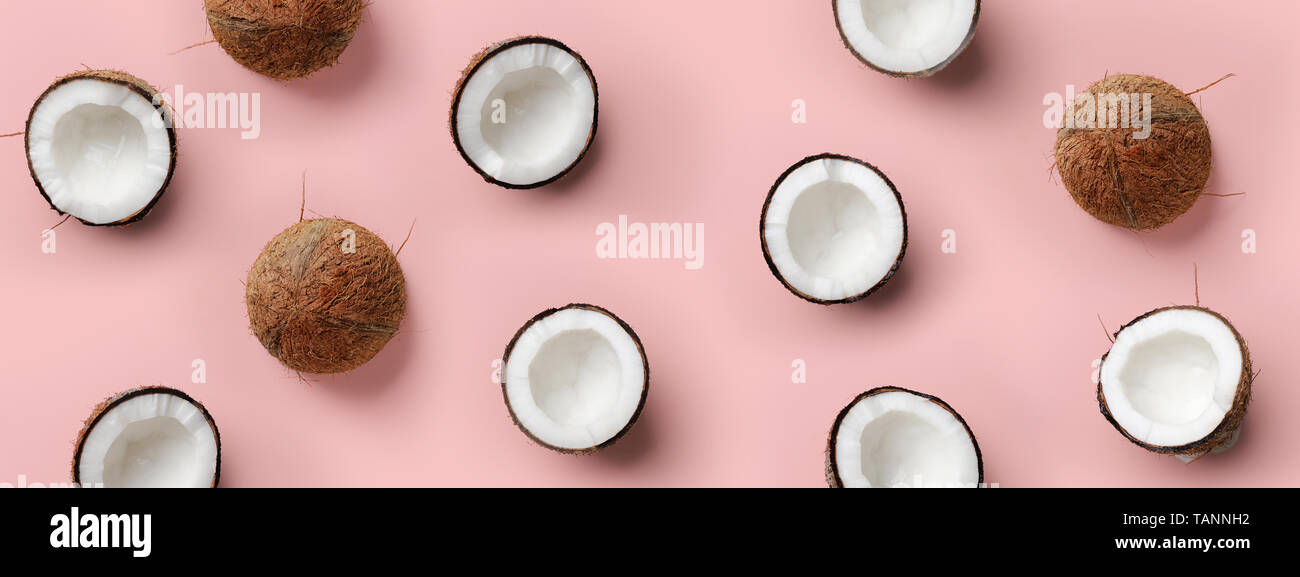 Avec motif sur coco mûre fond rose. Vue d'en haut. Copier l'espace. Pop art design, creative concept d'été. La moitié de la noix de coco dans un minimum de mise à plat Banque D'Images