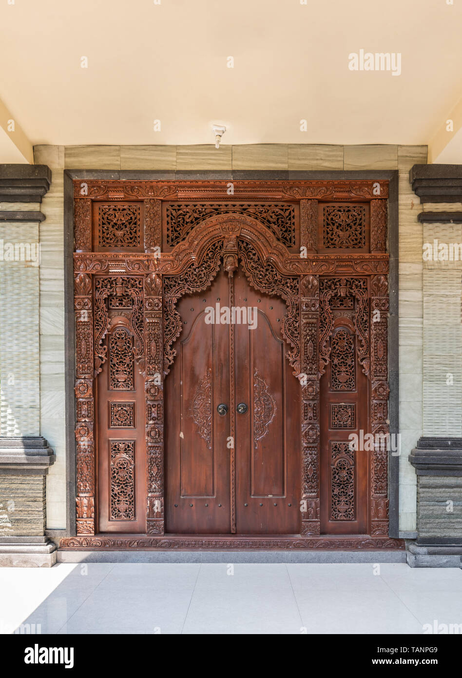 Dusun Ambengan, Bali, Indonésie - 25 Février 2019 : case familiale. Décorées marron porte d'entrée à l'un des appartements, répartis en gris-beige mur. Banque D'Images