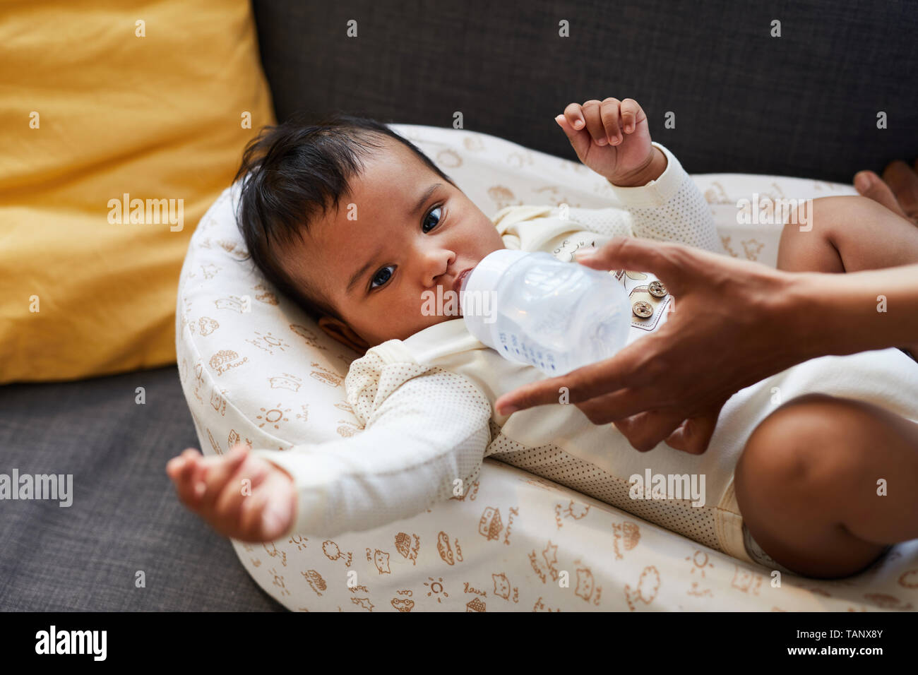 Close Up Of Serious Froncant Mignon Petit Garcon Noir Body En Couche Dans L Eau Claire Potable Et Cocoon A Partir De Bouteille De Bebe Donne Par Mere Photo Stock Alamy
