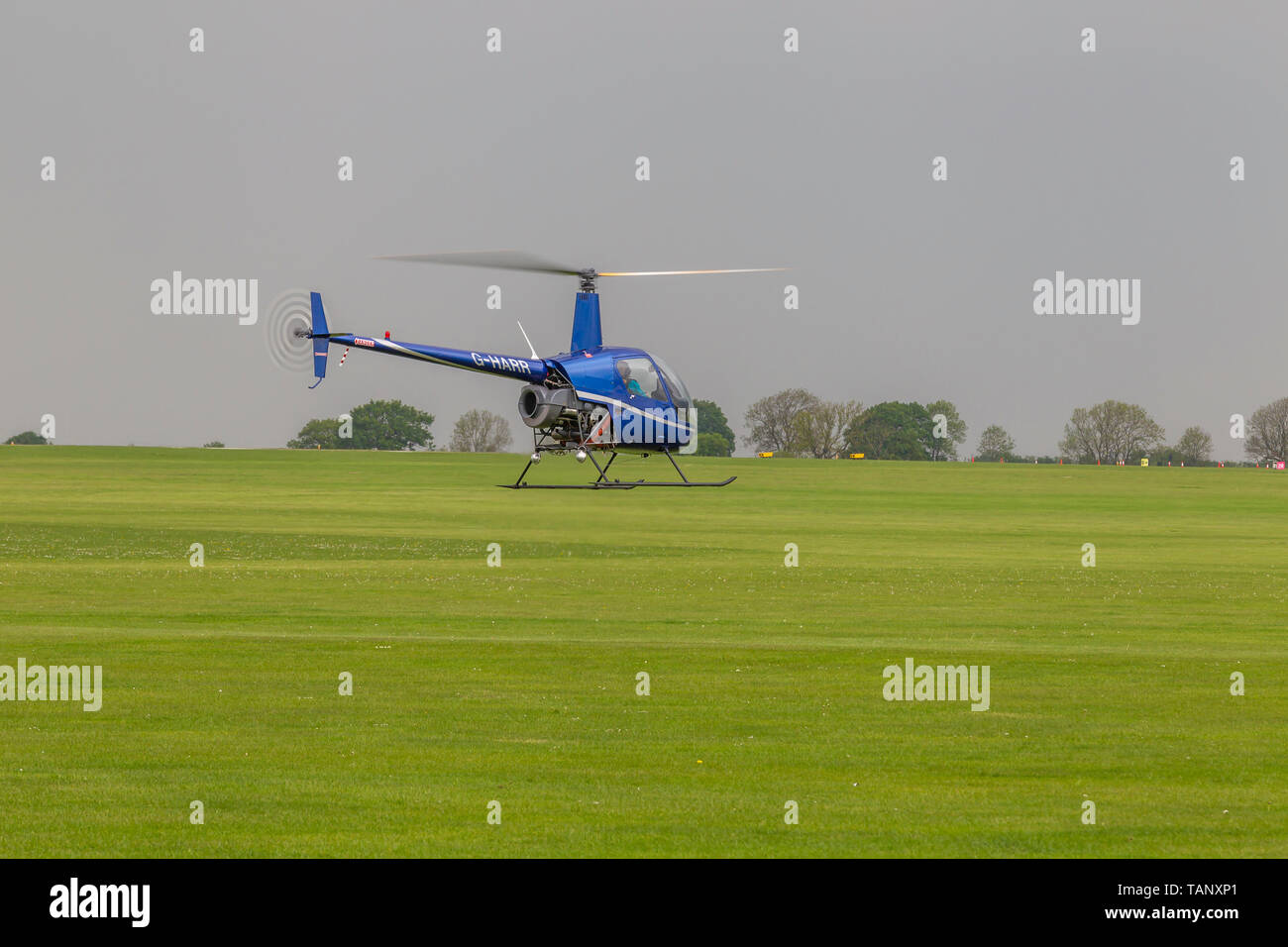 Un hélicoptère Robinson R-22 Beta voler contre un ciel sombre au cours de l'après-midi à Sywell Northamptonshire, l'aérodrome Banque D'Images
