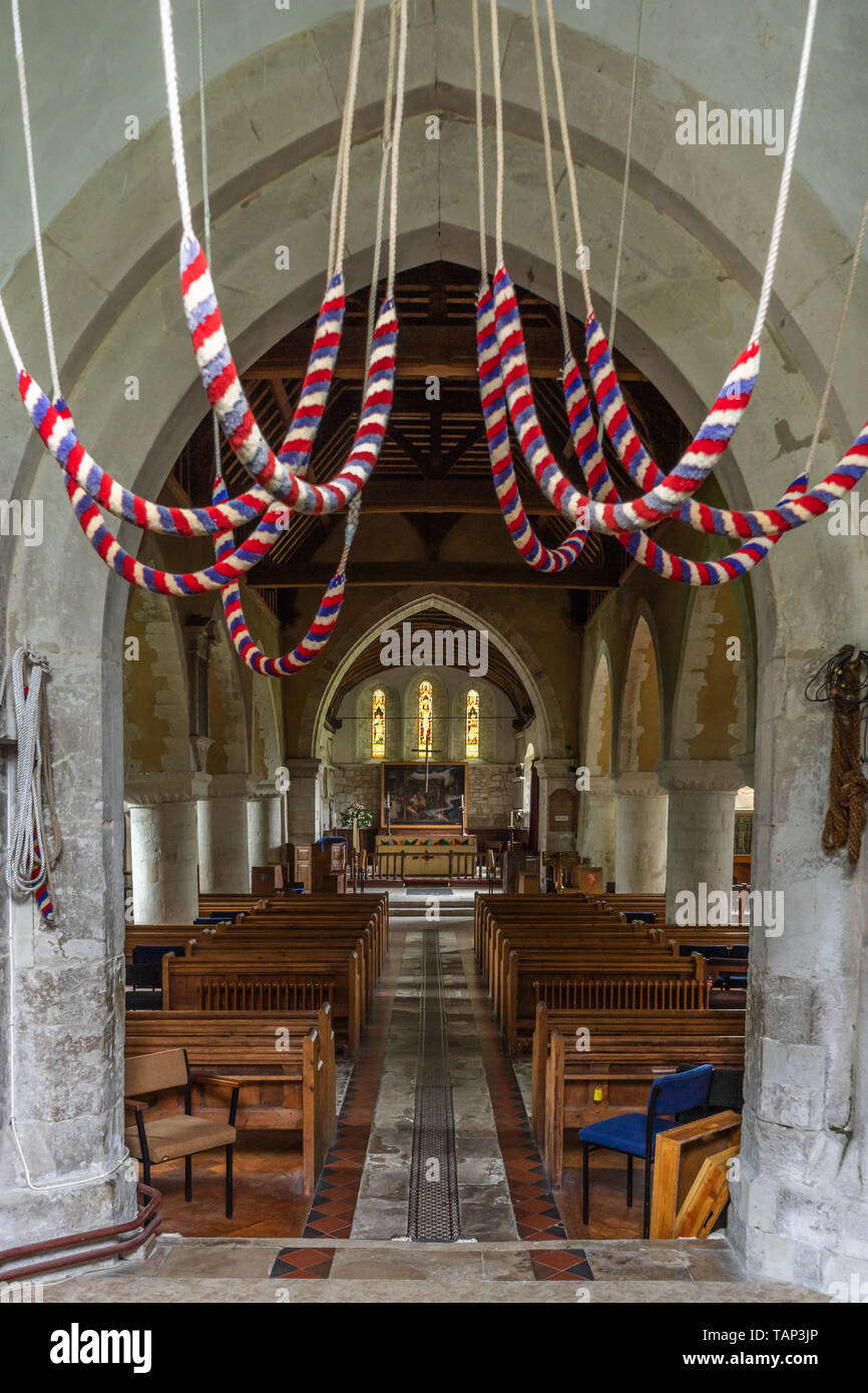 Cloche de l'église de cordes suspendues à la tour à l'intérieur de l'église St Mary avec vue de la nef vers l'autel, Selborne, Hampshire Banque D'Images