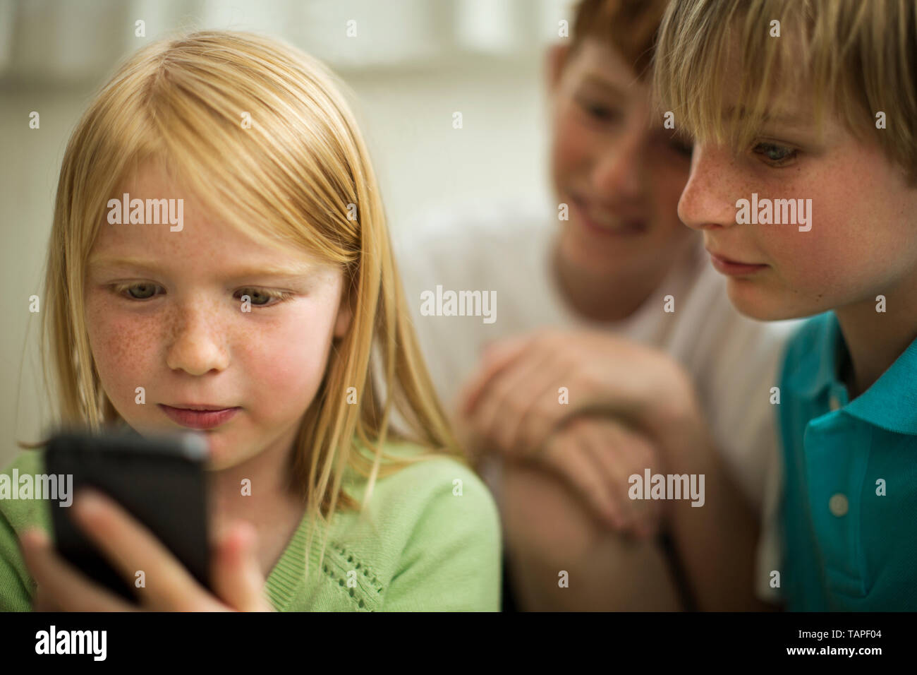 Les jeunes frères et sœurs à l'aide d'un téléphone intelligent. Banque D'Images