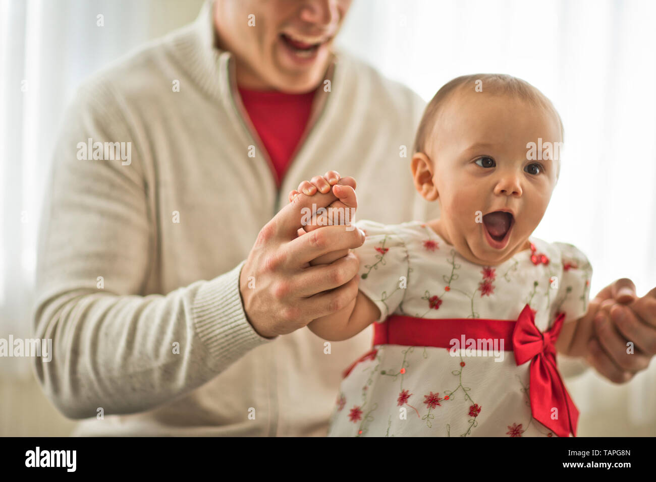 Jeune père de famille à l'appui de sa petite fille sur ses genoux. Banque D'Images