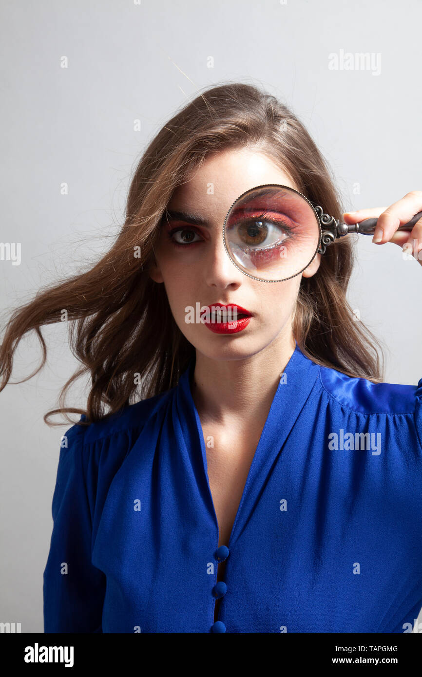 Woman Holding Loupe sur Eye Banque D'Images