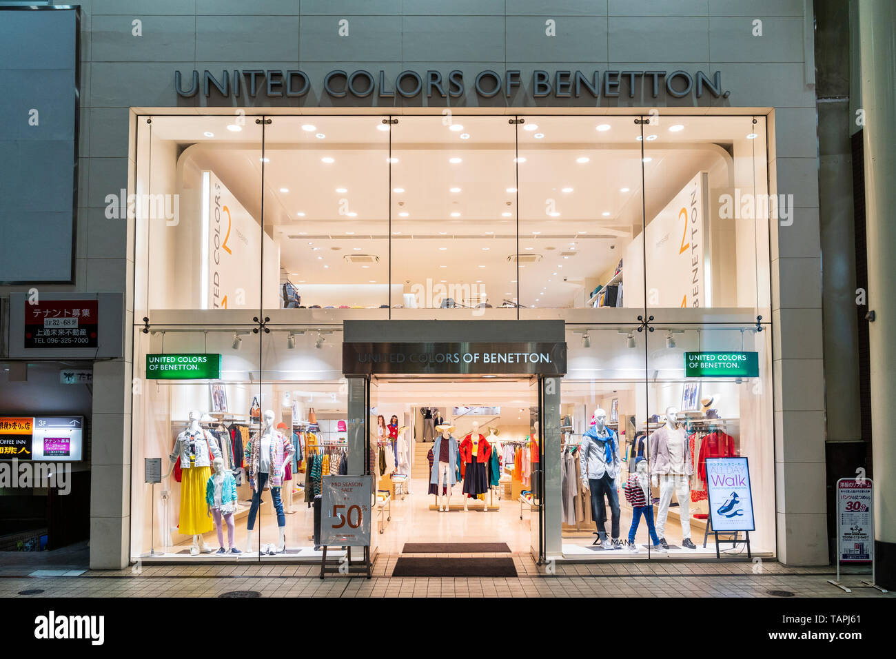 Magasin de vêtements à la mode Benetton dans Shimotori shopping arcade,  Kumamoto, Japon. Photo de nuit de l'extérieur de l'atelier ouvert à 50 %  vente signe par entrée Photo Stock - Alamy