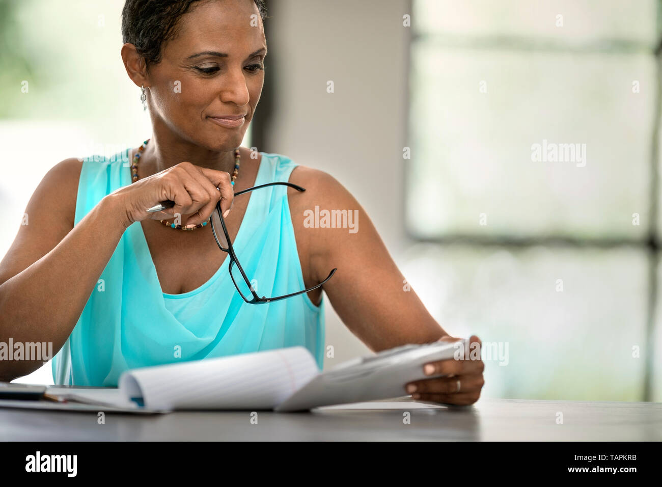 Femme lisant au comptoir de la cuisine Banque D'Images