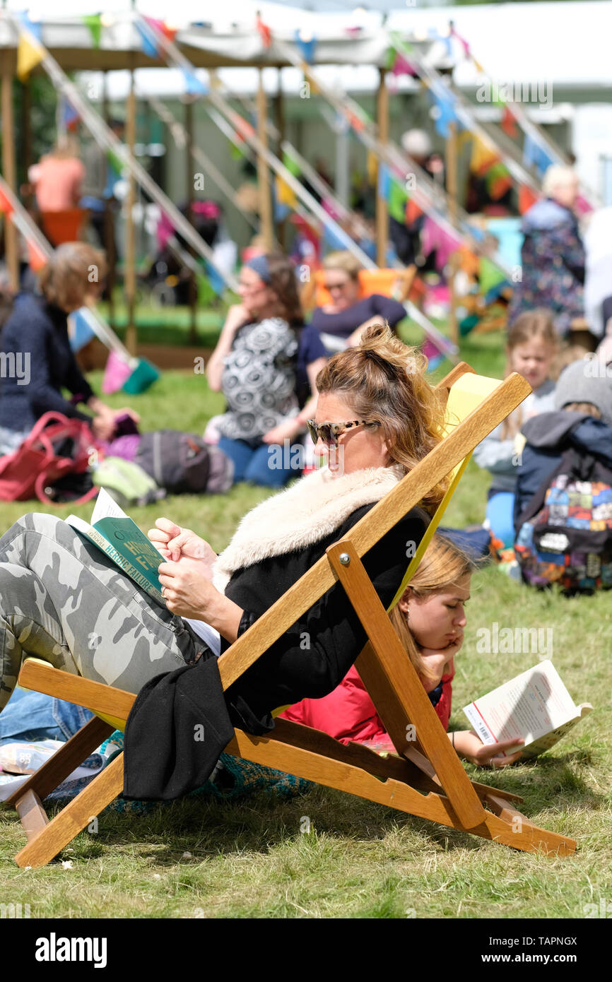 Hay Festival, Hay on Wye, Powys, Wales, UK - Lundi 27 mai 2019 - Les visiteurs apprécient la chance de lire sur les pelouses du Festival entre les événements et les haut-parleurs à l'Hay Festival on a sunny breezy cool mais lundi férié. Photo Steven Mai / Alamy Live News Banque D'Images