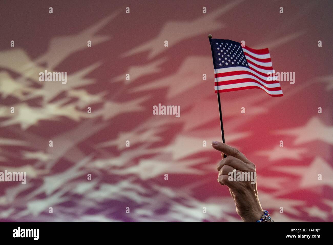 Un spectateur tenir un drapeau américain pendant le chant de l'hymne national à la National Memorial Day Concert sur la pelouse de l'ouest de la capitale américaine, 26 mai 2019 à Washington, D.C. Le concert est en souvenir des militaires qui ont donné leur vie pour le pays. Banque D'Images