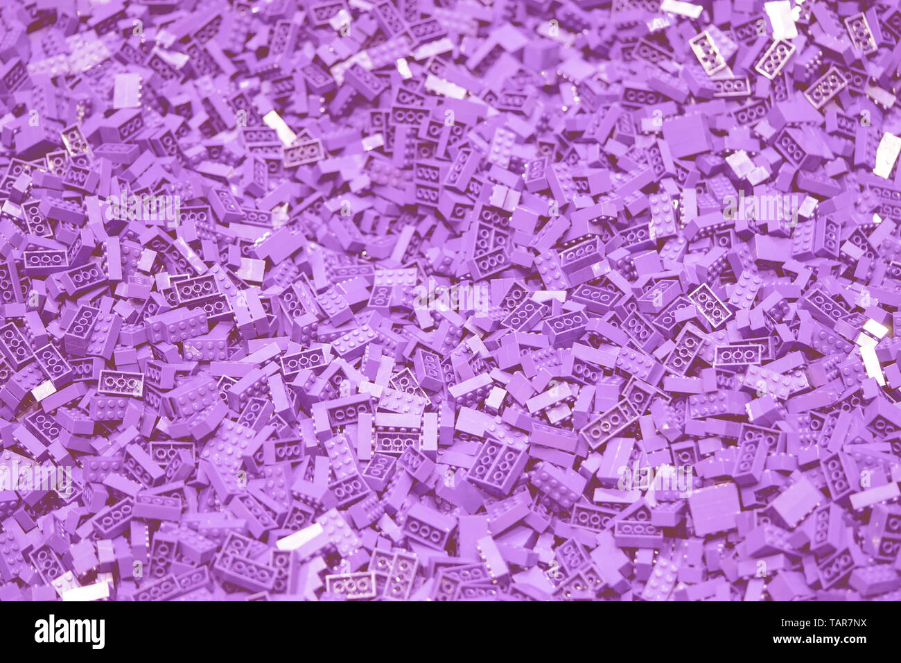 De nombreux jouets en plastique pour bloc violet texture background Banque D'Images