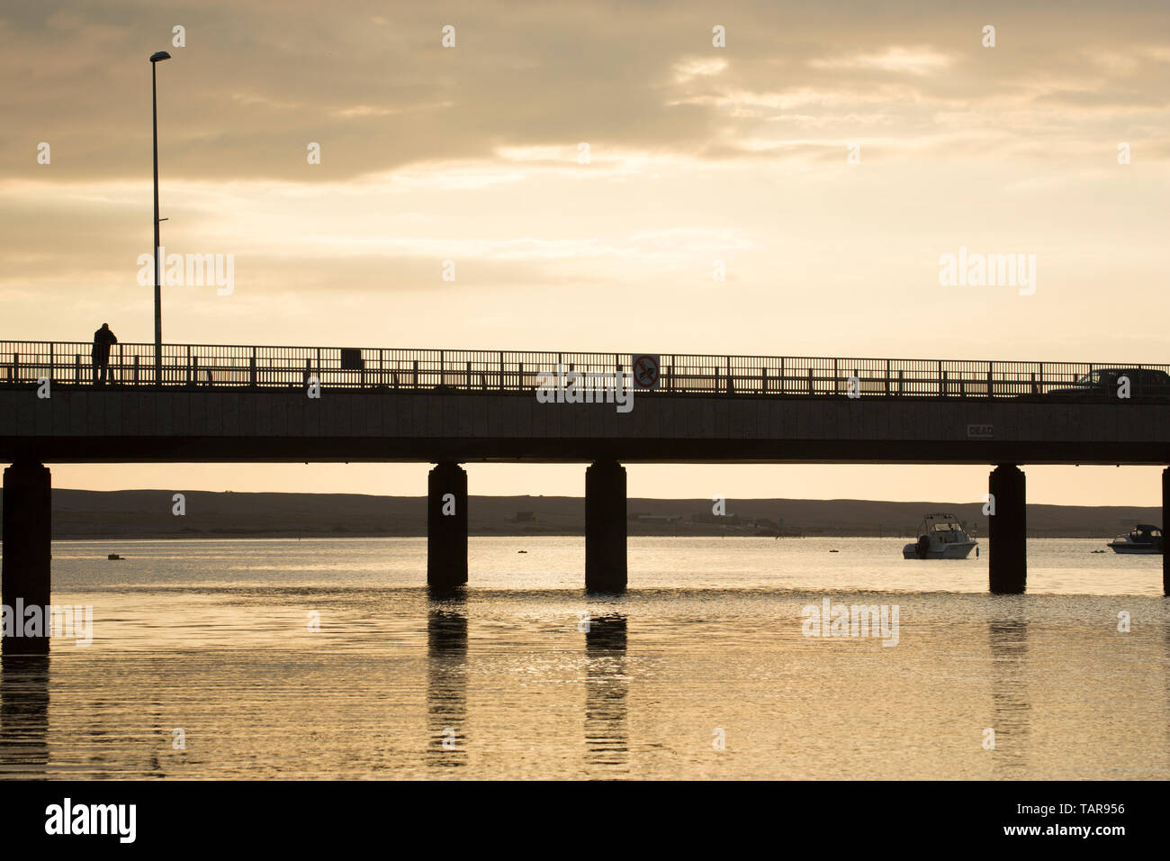 Un homme debout sur le pont à pont de ferry dans la soirée en mai. Pont transbordeur est au début de la chaussée qui mène à l'Île de Portland en Banque D'Images