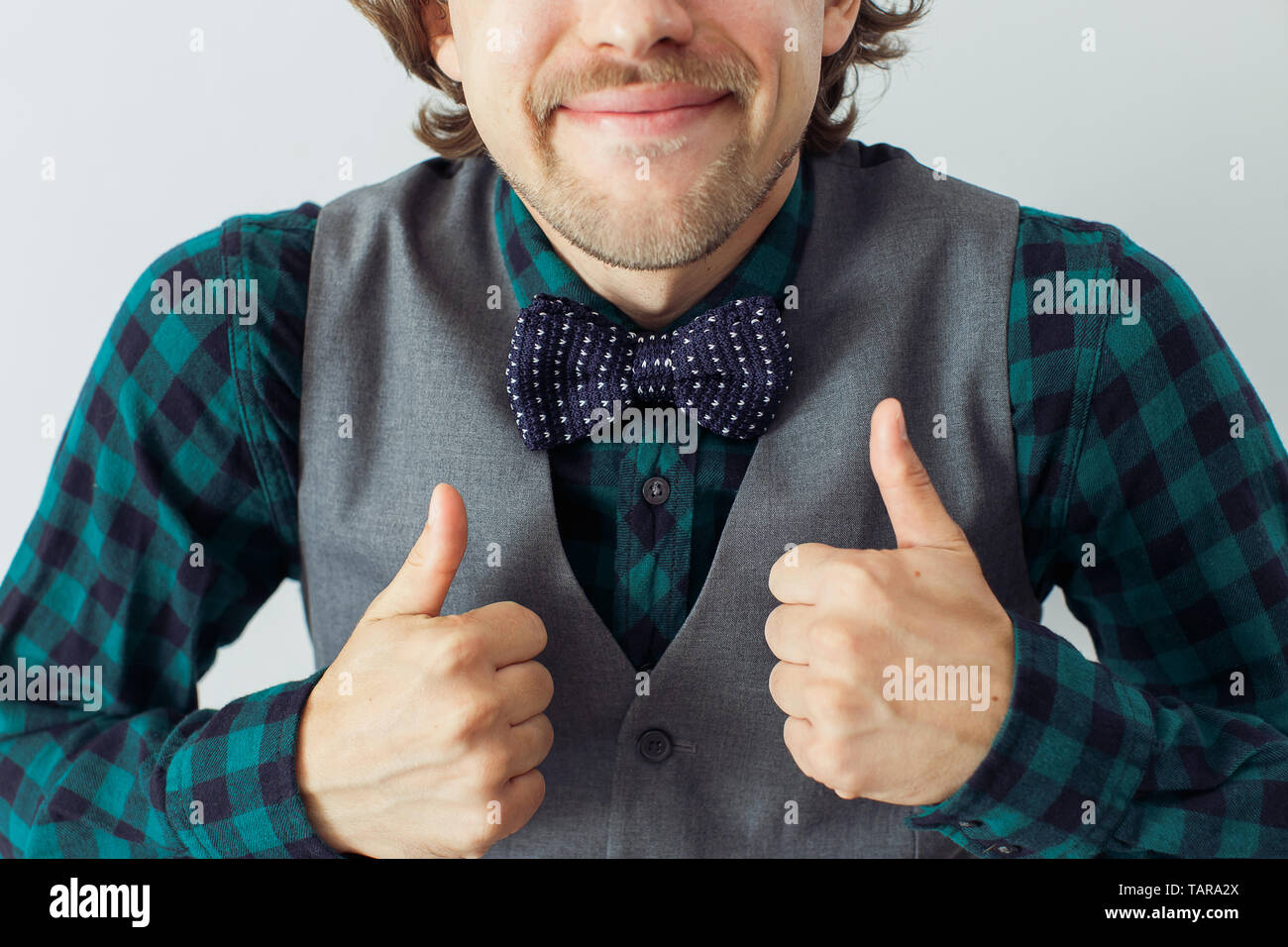 Homme avec barbe portant bowtie avec geste émotif, style hippie Banque D'Images