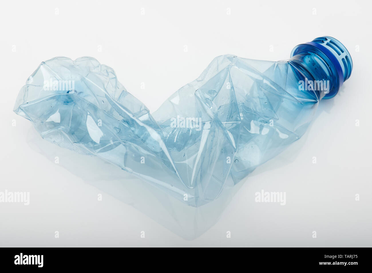 Thème déchets en plastique. Bouteille en plastique bleu blanc froissé isolé sur fond de studio Banque D'Images