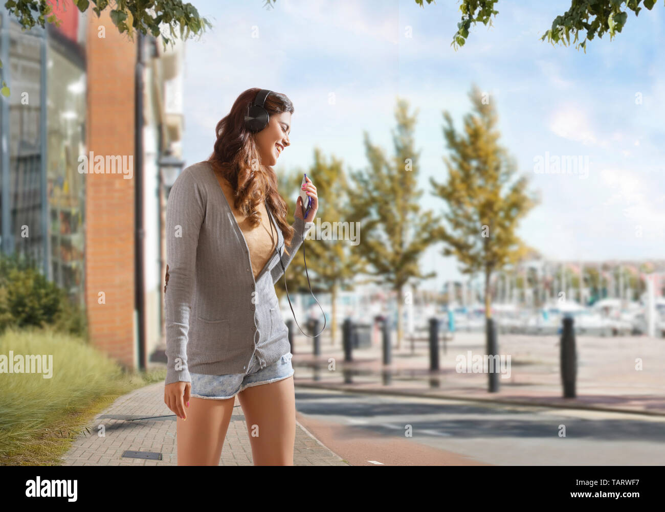 Young woman enjoying music standing outdoors Banque D'Images